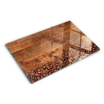 Tocător din sticlă Boabe de cafea pe un fundal de lemn