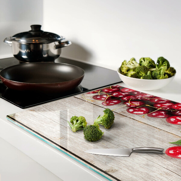 Tocător din sticlă Cireșe pe un fundal de lemn