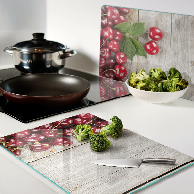 Tocător din sticlă Cireșe pe un fundal de lemn