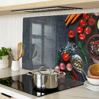 Tocător din sticlă Legume și condimente pe un fundal închis