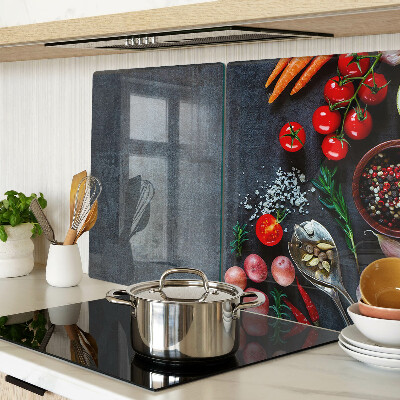 Tocător din sticlă Legume și condimente pe un fundal închis