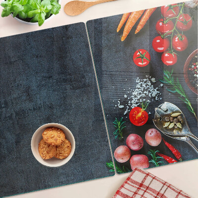 Tocător din sticlă Legume și condimente pe un fundal închis