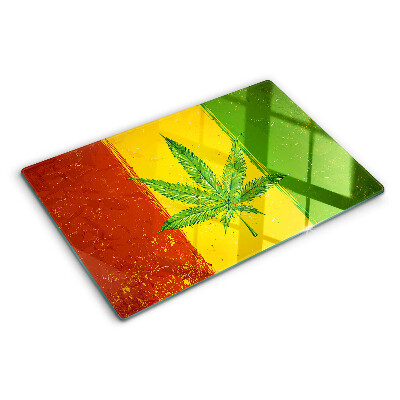 Tocător din sticlă Frunză de canabis pe un fundal colorat