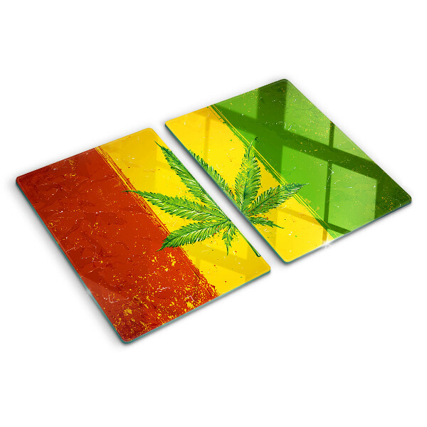 Tocător din sticlă Frunză de canabis pe un fundal colorat