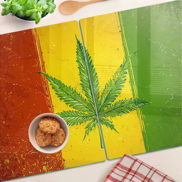 Tocător din sticlă Frunză de canabis pe un fundal colorat
