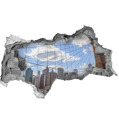 Autocolant un zid spart cu priveliște Vedere a orașului printr-o gaură în zid