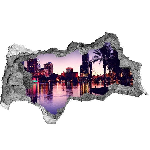 Autocolant un zid spart cu priveliște Apus de soare peste oraș