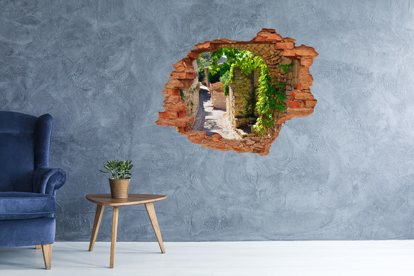 Autocolant un zid spart cu priveliște O stradă verde în oraș